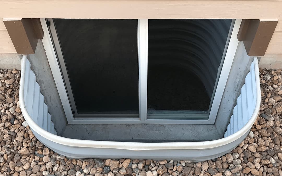 Window well with gravel surround and reflective glass for basement ventilation and light.