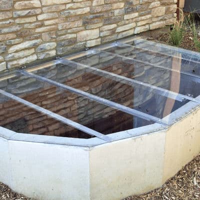 Modern stone foundation with a glass skylight cover for natural light and ventilation.