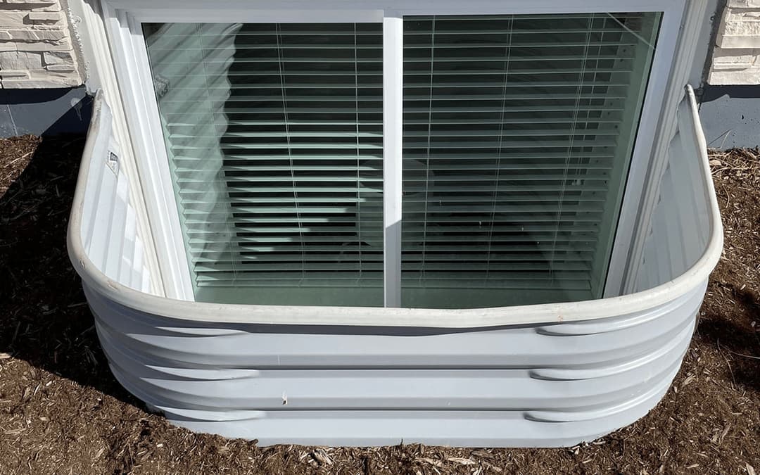 Window well with protective cover and blinds, featuring a clean, modern design.